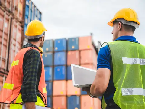 Zdjęcie przedstawia mężczyzn pracujących w spedycji i logistyce międzynarodowej 