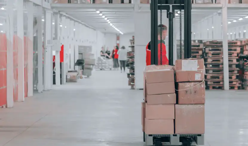 Employee transports products in a large warehouse after its packing