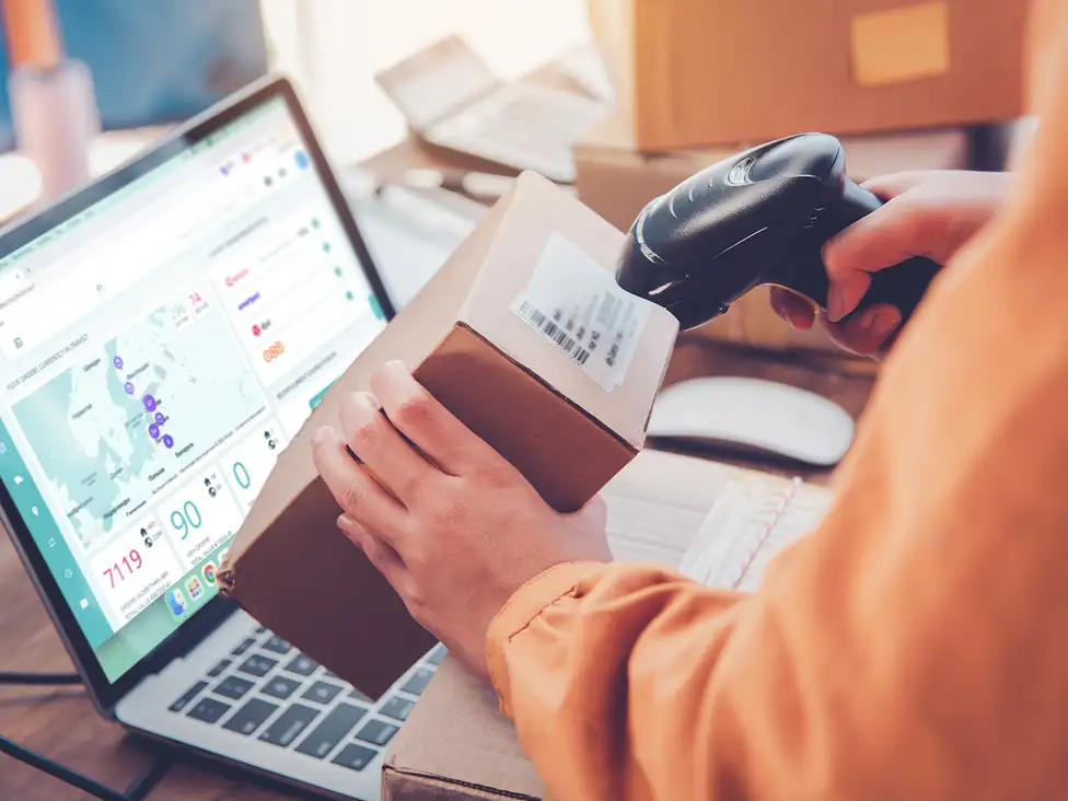 E-Commerce-Mitarbeiter scannt das Versandetikett eines Pakets
